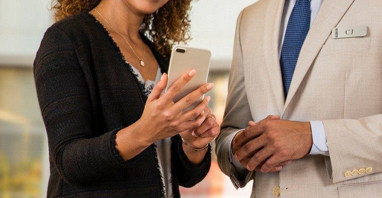 Two professionals discussing over a smartphone, enhancing business communication.